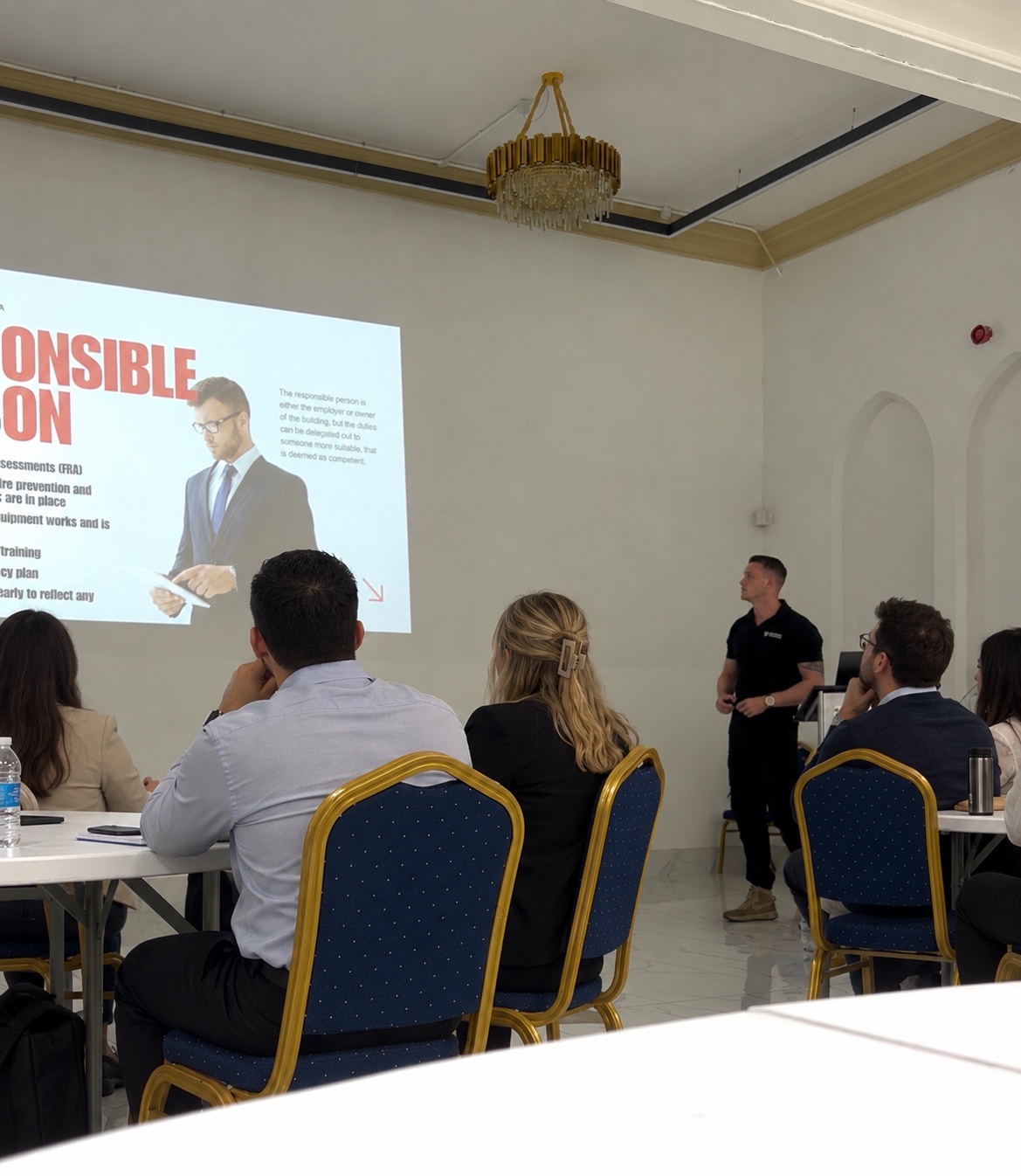A Phoenix instructor delivers fire marshal training to a group of seated learners